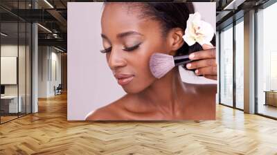 Cosmetic glow, makeup brush on face and black woman with skincare in studio, cosmetics tool. Skin care, blush and foundation, African beauty model with luxury contour highlight on pink background Wall mural