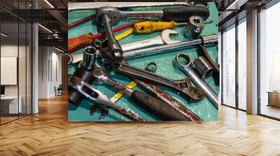 A close-up of various tools scattered across a work platform in the ship's engine room, each essential for the maintenance and repair of the main engine on a merchant vessel. Wall mural