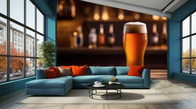 glass of beer on table with bar background Wall mural