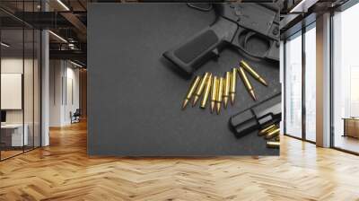 Handgun with rifle and ammunition on dark background with copy space Wall mural