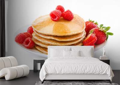 pancakes with berries on a plate over white background. Wall mural