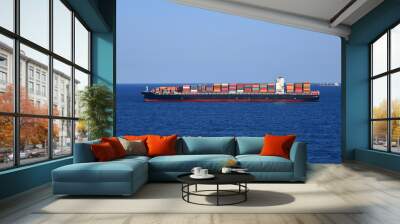 Cargo container ship loaded with containers during her voyage through the ocean.  Wall mural