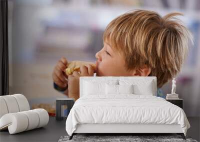 Food, breakfast and boy eating a sandwich in morning, pyjamas and home for nutrition. Children, hungry and meal for young male for lunch, childhood development and bread for health and wellness Wall mural