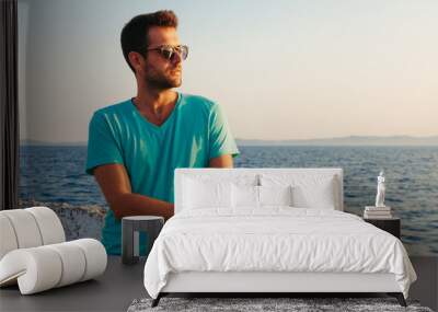 Beautiful man on the dock looking at sunset Wall mural