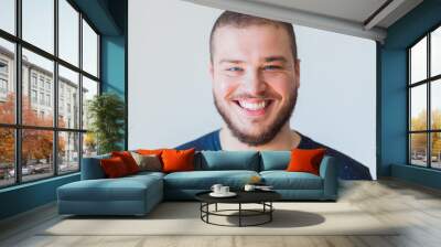 Portrait of a young bearded man smiling Wall mural