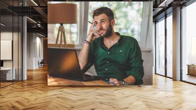 Young man having sressful time working on laptop Wall mural