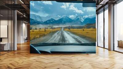 An aerial view of the landscape through the windshield of a car going across a meadow to high rocky mountains in different seasons with varying weather. The “natural landscape” is viewed from inside Wall mural