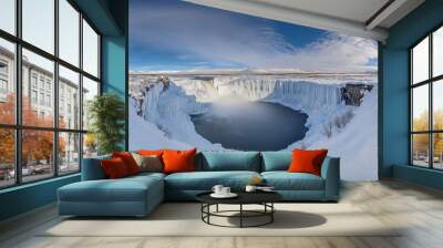 An overcast sky with snow on the ground and ice formations around the Goafoss waterfall in wintertime. Wall mural