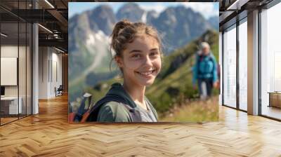 Angry teenage girl posing at a mountain top on a summer weekend with her family in the background. Adolescence and family concept. Wall mural