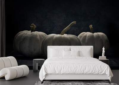 Three  white pumpkins lit in dramatic back light Wall mural