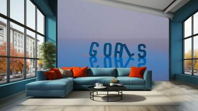 Blue letters on a reflective surface, spelling out the word goals. Wall mural