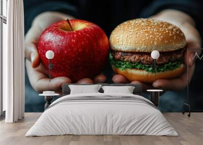 Close-up of hands holding a fresh red apple and a hamburger with lettuce. Concept of healthy eating choices versus fast food. Wall mural