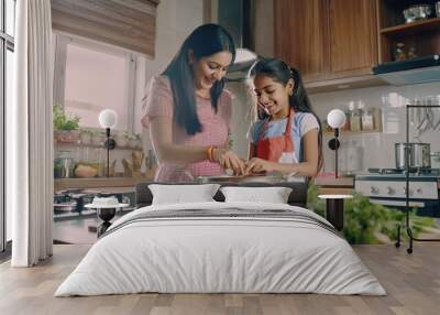 Cooking food at the kitchen of a young Indian mother and daughter Wall mural