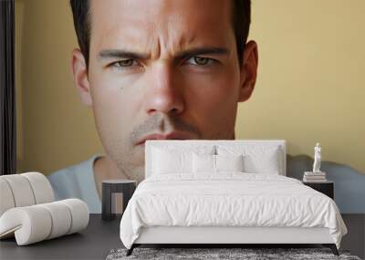 A studio close-up portrait of a young white man wearing a casual t-shirt, with a colourful background. Wall mural