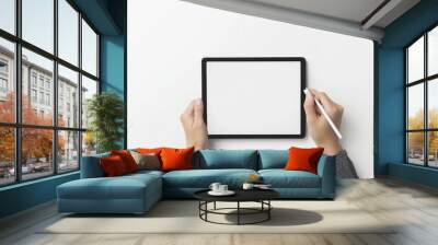 Hand holding a mockup tablet and pencil on white background with a blank screen Wall mural