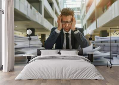 Overwhelmed businessman struggling with excessive paperwork. Wall mural