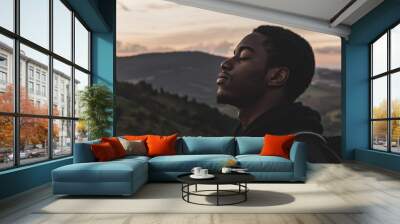 The forest is filled with fresh air as a black man breathes it in. Stock photo. Wall mural