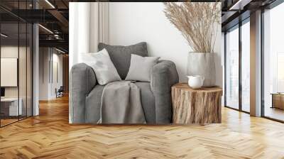 The rustic wooden log lounge armchair, two stump tables and a wooden vase with twigs are placed against a blank white wall with copy space. Wall mural