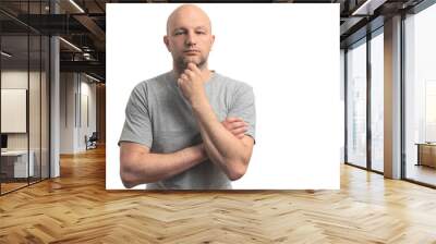 Bold man in grey t-shirt on white background, thoughtful expression, unshaven, caucasian, slim, fit. Wall mural