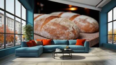 Homemade wheat loaves are baked in the oven on a baking stone. Close-up, selective focus Wall mural