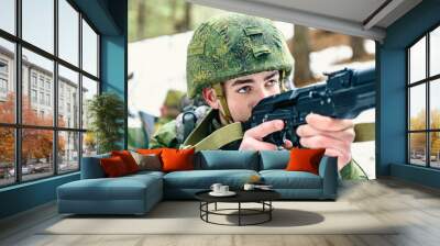 The soldier of the Russian army in anticipation of the enemy, is aiming from the automatic weapon at the target Wall mural