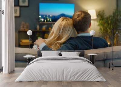  Young lovely couple hugging on couch in home living room watching a movie on movie date night Wall mural