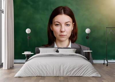 Annoyed business woman, copy space of a businesswoman in suit with expression of disappointment and disgust, envious and vindictive boss at work on a green background Wall mural