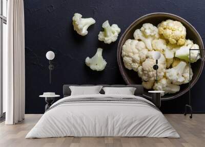 Cauliflower in a bowl on a black background, top view, copy space  Wall mural