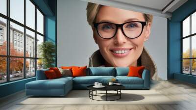 Close up middle aged stylish woman wearing eyeglasses smiling isolated over light gray background Wall mural