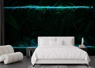 Concept of green leaves and neon blue light. Flat lay photo on the black backdrop. Wall mural