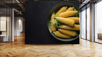 Corn in a bowl on a black background, top view, copy space Wall mural