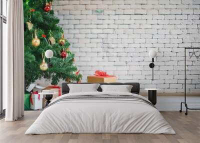 decorated christmas tree and gift boxes over white brick wall with copy space Wall mural