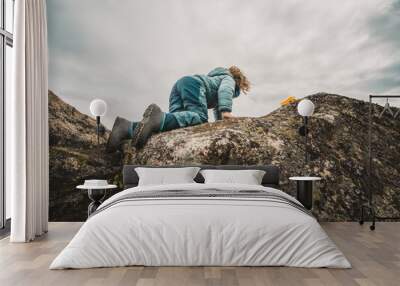 A young boy is climbing a rock Wall mural