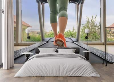 Fitness woman running on treadmill in gym Wall mural