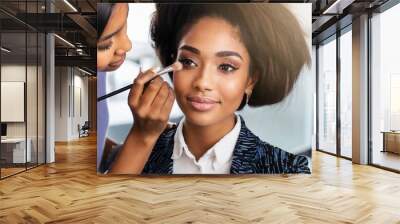 Makeup artist applying make up on beautiful young woman face. Beauty, fashion Wall mural