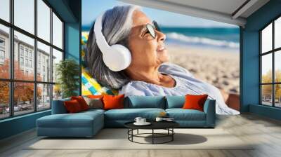 old woman with gray hair listen to music with headphones on vacation Wall mural