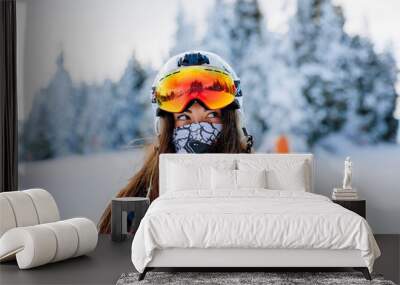 Ski, skier, sun and winter fun - woman enjoying ski vacation. Sport, leisure and people concept - happy young woman in ski goggles outdoors. Ski resort - Image Wall mural