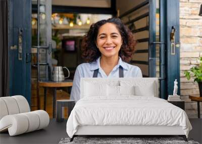 Smiling woman is standing at the entrance doors of her store. In the coffee shop, a cheerful middle-aged waitress is waiting for customers. Small business owner is standing at the entrance Wall mural