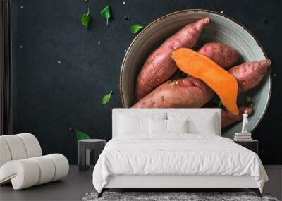 Sweet potato in a bowl on a black background, top view, copy space Wall mural