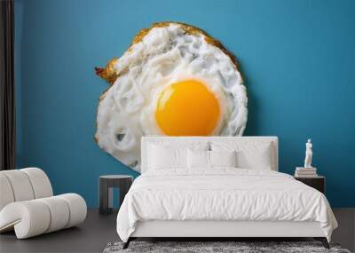 Tasty sunny side up fried egg isolated on a blue background Wall mural