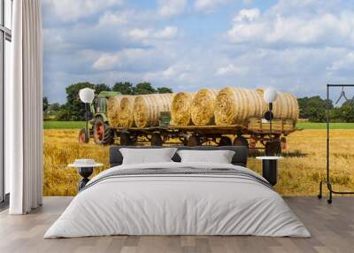 tractor pulling two trailers with hay bales Wall mural