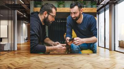 two friends watching media content in a smart phone Wall mural