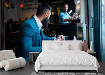 Two male friends chatting in a bar Wall mural