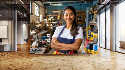 woman, standing in a well-organized workshop filled with various tools Wall mural