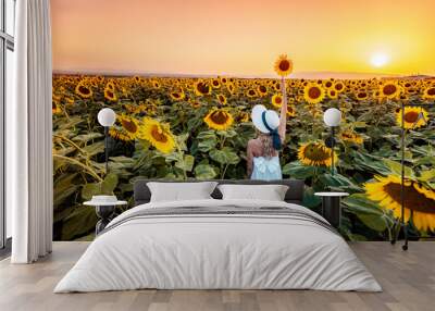 Woman in White Dress Holds Sunflower in Field at Sunset Wall mural