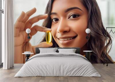 Yellow vitamin capsule in a woman's hand close-up Wall mural