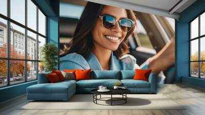 young adult woman driving a car, smiling joyfully Wall mural