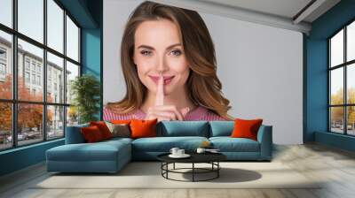 young secret smiling caucasian woman she wearing casual clothes saying hush be quiet with finger on  Wall mural