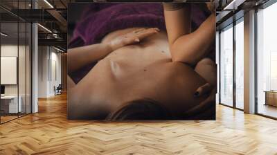 Young woman getting a back massage with elbow in therapy room Wall mural