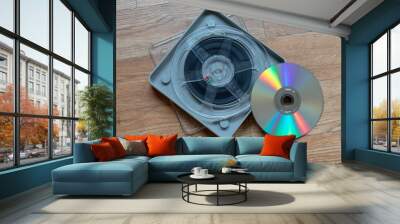 Old used film reel beside a dvd on a wooden table Wall mural